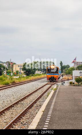 Ein Zug fährt in einen Bahnhof und wartet in Thailand auf Fahrgäste Stockfoto