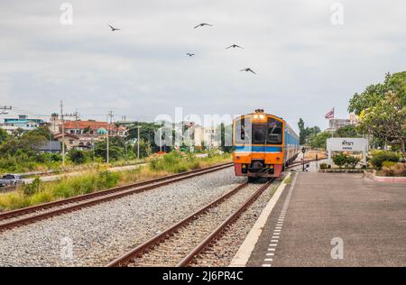 Ein Zug fährt in einen Bahnhof und wartet in Thailand auf Fahrgäste Stockfoto