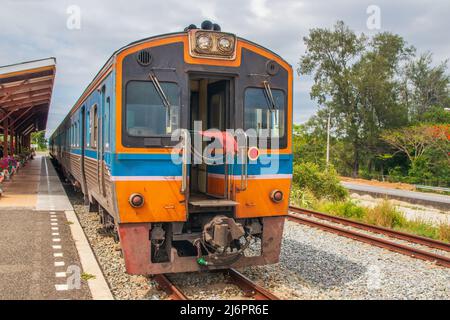 Ein Zug fährt in einen Bahnhof und wartet in Thailand auf Fahrgäste Stockfoto