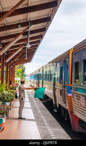 Ein Zug fährt in einen Bahnhof und wartet in Thailand auf Fahrgäste Stockfoto