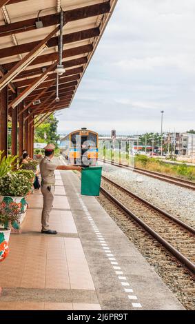 Ein Zug fährt in einen Bahnhof und wartet in Thailand auf Fahrgäste Stockfoto