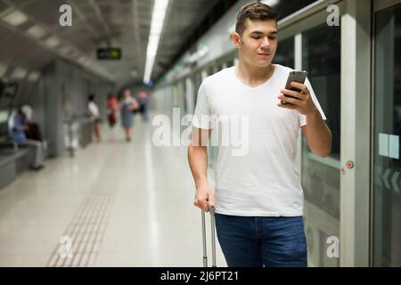 Mann, der sein Telefon an der U-Bahn-Station benutzt Stockfoto