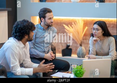 Drei Mitarbeiter des Unternehmens, die das Treffen abhalten Stockfoto
