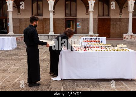 Venedig, Italien - April, 20: Die Chefin und ihre Mitarbeiterin bereiten sich darauf vor, am 20. April 2022 Canapes-Vorspeisen für das Buffet zuzubereiten Stockfoto