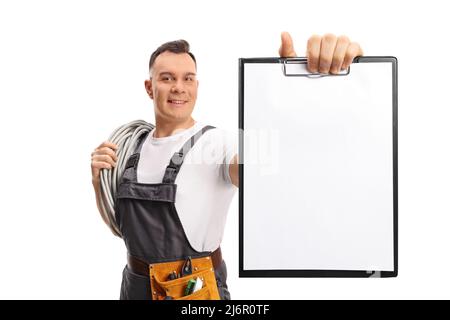 Elektriker, der Kabel auf der Schulter trägt und eine Zwischenablage mit einem auf weißem Hintergrund isolierten Papierdokument zeigt Stockfoto