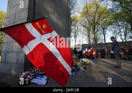 03. Mai 2022, Hamburg: Darion Akins (r), Generalkonsul der USA, erinnert an die Opfer der Gedenkstätte, nachdem er anlässlich des 77.. Jahrestages des Kriegsendes und der Befreiung der Gefangenen in der KZ-Gedenkstätte Neuengamme einen Kranz niedergelegt hatte. Überlebende sowie Mitgliedsorganisationen der Amicale Internationale KZ Neuengamme und andere Verwandte ehemaliger KZ-Häftlinge aus Belgien, Dänemark, Deutschland, Frankreich, Kroatien, Die Niederlande, Polen, Spanien und die Ukraine nahmen an der Gedenkfeier Teil. Foto: Marcus Brandt/dpa Stockfoto