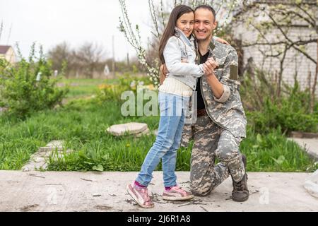 Schöner Soldat an einem sonnigen Tag wieder mit der Familie vereint. Stockfoto