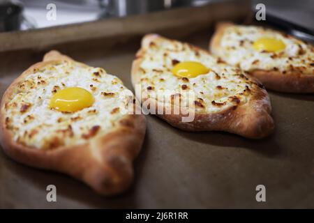 Khachapuri in Adjarian. Offener Kuchen mit Mozzarella und Ei. Traditionelle georgische Küche. Schritt für Schritt. Schritt 2. Stockfoto