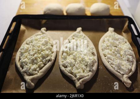 Khachapuri in Adjarian. Offener Kuchen mit Mozzarella und Ei. Traditionelle georgische Küche. Schritt für Schritt. Schritt 1. Stockfoto