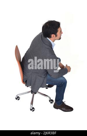 Hochwinkelansicht eines Mannes, der sitzt, Seitenansicht, auf weißem Hintergrund Stockfoto