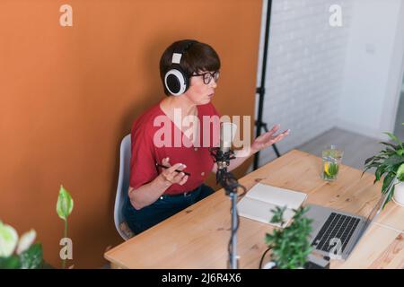 Radiomoderatorin mittleren Alters, die Podcast-Aufnahmen für Online-Shows macht – Broadcast und dj-Konzept Stockfoto