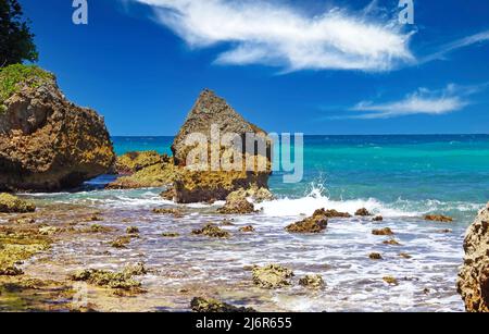 Wunderschöne felsige raue karibische Küstenlandschaft, türkisfarbenes Meer, spektakulärer blauer Himmel, weiße Wolken - San san San Beach, Port Antonio, Jamaica Stockfoto
