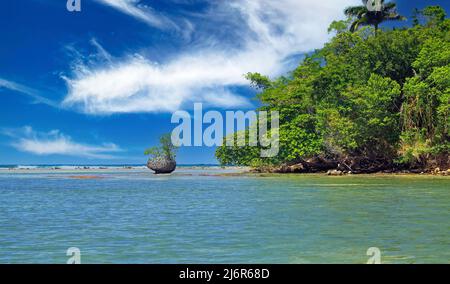 Wunderschöne karibische abgeschiedene Lagunenlandschaft mit blauem Riff, ein isolierter Felsblock, Mangrovenbaumwald, blauer Himmel, flauschige Wolken - Port Antonio, San San Stockfoto
