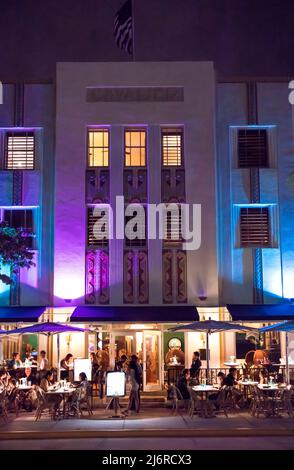 Menschen, die abends außerhalb des Art-Deco-Restaurants in South Beach, Miami, Florida, USA, speisen Stockfoto