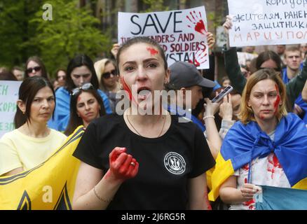 Kiew, Ukraine - am 03. Mai 2022 singt Ein Protestler mit roten Gemälden Slogans während der Demonstration. Verwandte und Freunde der Soldaten des Bataillons Asov, die derzeit das Asowstal-Werk in Mariupol verteidigen, rufen die führenden Politiker der Welt dazu auf, einen grünen Korridor für die Evakuierung von Zivilisten und ukrainischen Soldaten aus dem Asowstal-Stahlwerk zu schaffen. Stockfoto