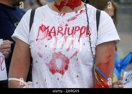 Kiew, Ukraine - am 03. Mai 2022 Nimmt Ein Protestler mit roter Malerei an der Demonstration Teil. Verwandte und Freunde der Soldaten des Bataillons Asov, die derzeit das Asowstal-Werk in Mariupol verteidigen, rufen die führenden Politiker der Welt dazu auf, einen grünen Korridor für die Evakuierung von Zivilisten und ukrainischen Soldaten aus dem Asowstal-Stahlwerk zu schaffen. Stockfoto