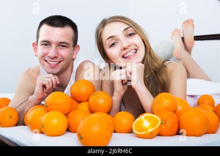 Paar mit Orangen im Bett Stockfoto