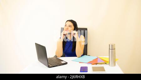 Nette und schöne erfolgreiche Geschäftsführerin, asiatische Frau, in blauer Bluse, arbeitet am Laptop, konzentriert, glücklich und denkt über ihre Zukunft nach, auf weißem Hintergrund Stockfoto