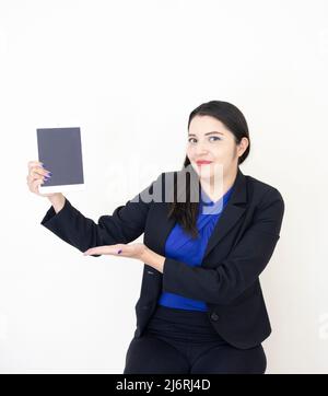 Nette und erfolgreiche Geschäftsführerin, die in schwarzem Anzug und blauem Bluse arbeitet und hart an ihrem Tablet auf weißem Hintergrund arbeitet Stockfoto