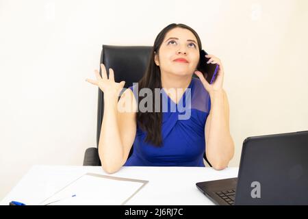 Nette erfolgreiche CEO-Assistentin trägt blaue Bluse hoffentlich Anruf auf Handy, Laptop-Schreibtisch, auf weißem Hintergrund Stockfoto