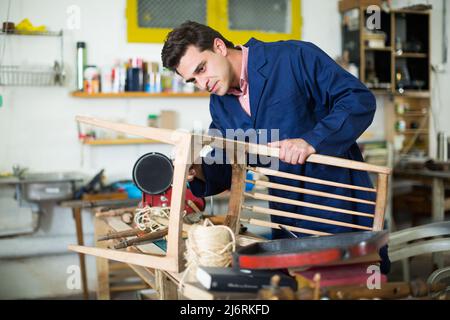 Handwerker Reparatur Stuhl in der Werkstatt Stockfoto