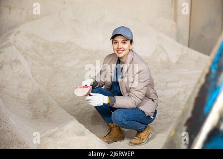 Eine Bäuerin hockt auf einem Haufen Maismehl Stockfoto