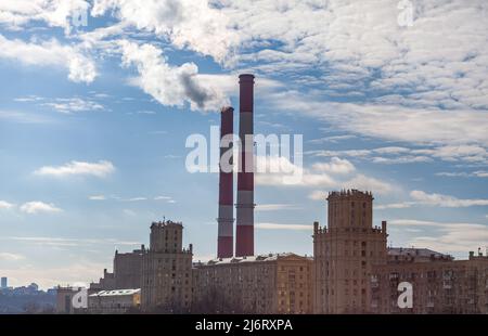 CHP in der Stadt. Aus den Wärmerohren des Kraftwerks steigt Rauch in den Himmel. Rohr aus Blockheizkraftwerk KWK oder Kraft-Wärme-Kopplung gegen BA Stockfoto