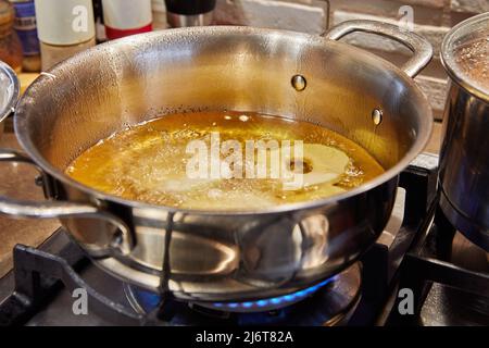 Kochen von Apfelpfannkuchen. Apfeldonut in kochendem Öl. Stockfoto