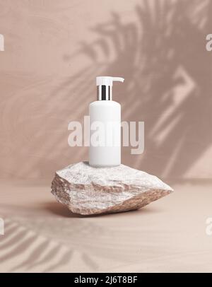 Kosmetische Flasche Mockup auf beige Wand Hintergrund auf dem grauen Stein Podium, um Ihr Design zu platzieren, 3D Rendering, 3D Illustration. Produktverpackungsmarke Stockfoto