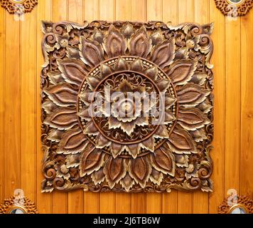 Das Blumenmuster auf der Holzschnitzerei ist an der Decke der Eingangshalle des Hotels angebracht, Vorderansicht für den Hintergrund. Stockfoto