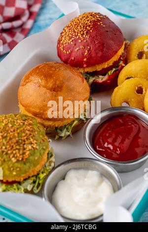 Drei Mini-Burger mit Huhn und Fleisch serviert mit pommes frites. Kindermenü Stockfoto