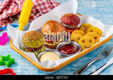Drei Mini-Burger mit Huhn und Fleisch serviert mit pommes frites. Kindermenü Stockfoto