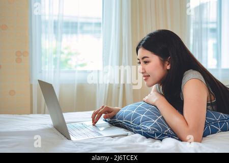 Portrait asiatische Frau mit Computer Laptop oder Tablet im Schlafzimmer Arbeit von zu Hause, Technologie Kommunikation Lebensstile Konzept. Stockfoto