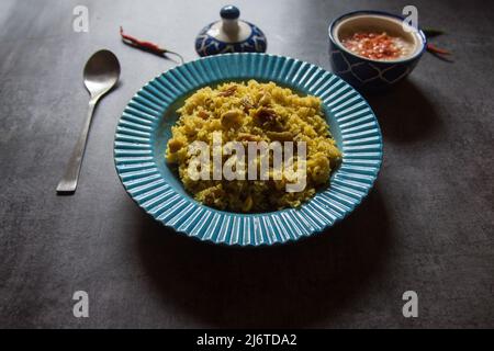 Pulao- oder Basmati-Reis mit indischen Gewürzen und trockenen Früchten in einer blauen Schüssel serviert. Nahaufnahme, selektiver Fokus. Stockfoto