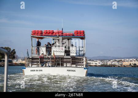 Ausflugsboot 'Amor da Ilha' direkt vor unserem Solarboot in Tavira im Naturresort Ria Farmosa Stockfoto