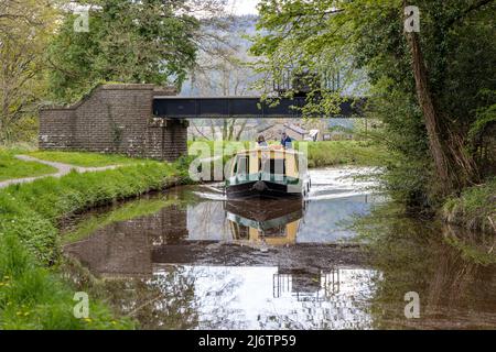 Narrowboat-Urlauber steuern den Monmounthshire und den Brecon Canal in der Nähe von Talybont-on-Usk in den Brecon Beacons, Powys, South Wales, Großbritannien Stockfoto