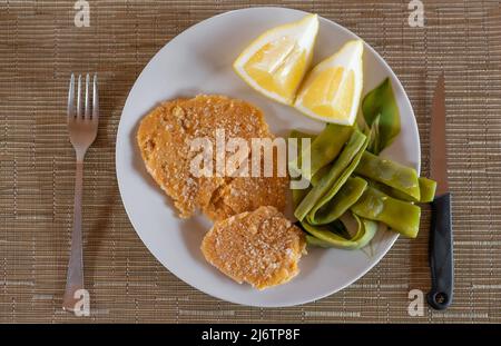 Vegane Kichererbsenschnitzel mit Gemüse und Zitrone Stockfoto