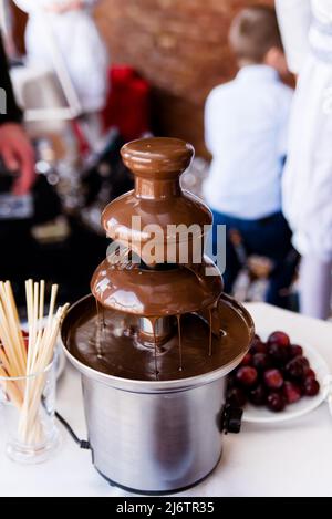 Lebendige Bild der Schokoladenbrunnen Fontain auf Kinder Kindergeburtstag mit einem Zicklein herum spielen und Marshmallows und Früchte Tauchen Tauchen f Stockfoto