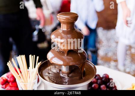 Lebendige Bild der Schokoladenbrunnen Fontain auf Kinder Kindergeburtstag mit einem Zicklein herum spielen und Marshmallows und Früchte Tauchen Tauchen f Stockfoto