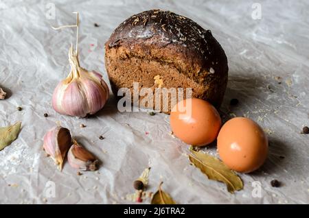 Stillleben von Brot, Eiern, Knoblauch und Gewürzen Stockfoto