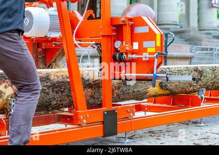 Tischler auf einem mobilen Sägewerk. Sägen von Baumstämmen auf Brettern Stockfoto