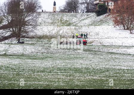 London, Großbritannien - 19. März 2022 - Parkranger errichten Zaun am Greenwich Park bedeckt mit Winterschnee Stockfoto