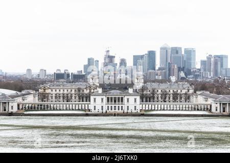 London, Großbritannien - 19. März 2022 - Blick auf das Queens House und Canary Wharf vom Greenwich Park im Winterschnee Stockfoto