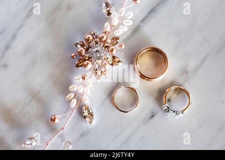 Kostbare Haarnadel und Eheringe auf Stein. Stockfoto