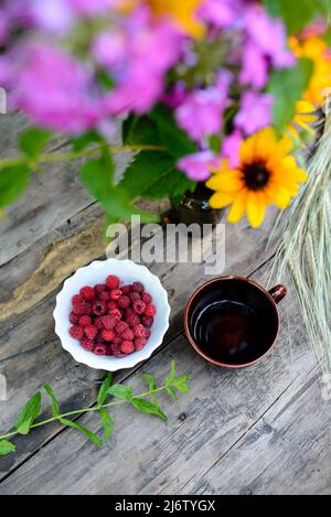 Stillleben von Blumen, Himbeeren und Tee Stockfoto