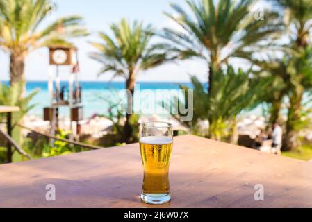 Ein Glas Bier gegen das Meer Stockfoto