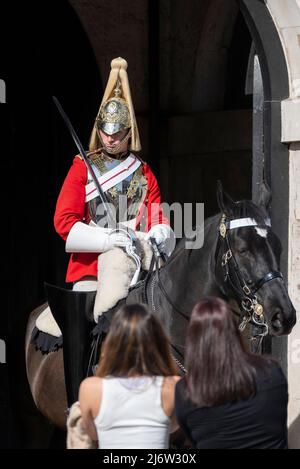 Rettungsschwimmer der britischen Armee des Haushalts-Kavalleriesoldaten im zeremoniellen Wachdienst bei Horse Guards, London, Großbritannien. Weibliche Touristen sehen Trooper Stockfoto