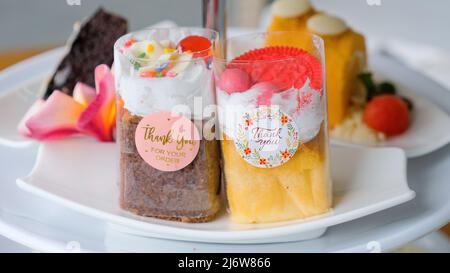 Auswahl an Süßigkeiten, Kuchen, Schokoladenkuchen und Schokoladenbrownie auf weißem Teller Stockfoto