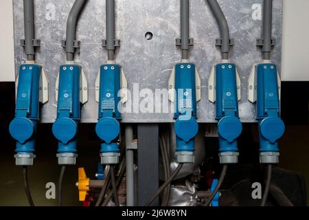 Blaue Stecker für dreiphasige Stromversorgung in einer industriellen Umgebung zum Antrieb von Pumpen und Ventilatoren oder Heizung Stockfoto