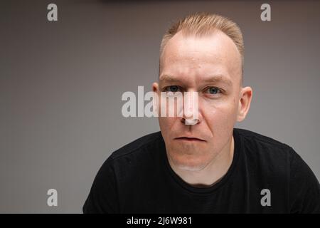 Nahaufnahme des reservierten Mannes in schwarzem Hemd Stockfoto